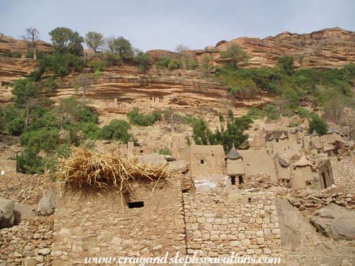 Dogon village with Tellem cliff dwellings above Dogon village with Tellem cliff dwellings above