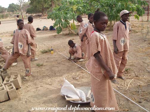 Kids measure out where to plant the trees