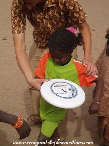 Anna teaches Daniel's daughter to throw the frisbee Anna teaches Daniel's daughter to throw the frisbee