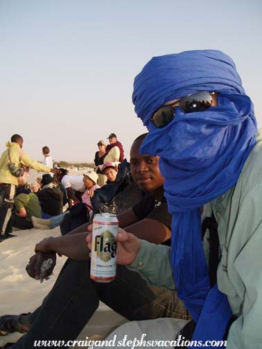 Craig and El Hadj on the dune with a frosty Flag beer