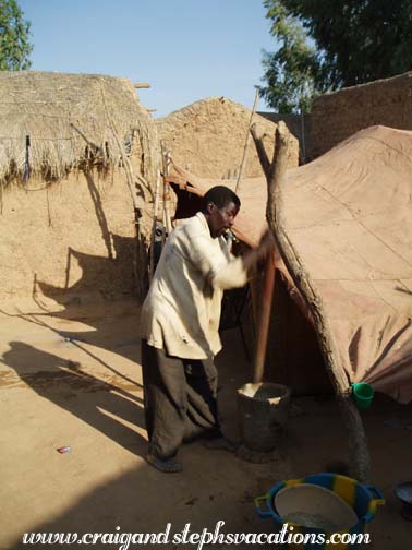 Bozo man demonstrates pounding millet