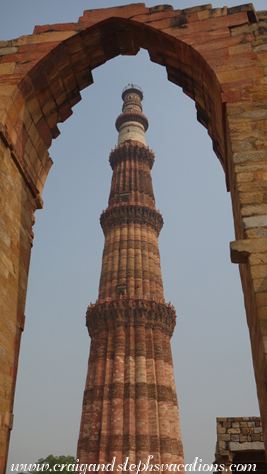 Qutub Minar viewed through an archway in the mosque complex