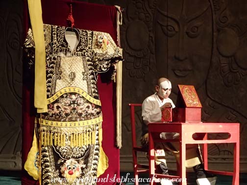 Beijing Opera actor sits on stage to apply his make up
