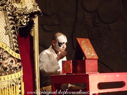 Beijing Opera actor sits on stage to apply his make up