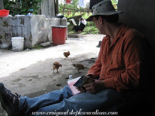 Craig watches the chickens as he writes out postcards