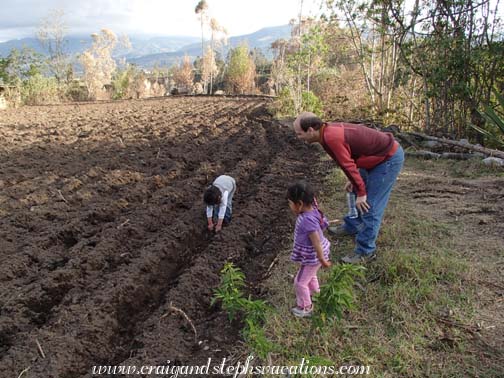 Craig and Tayanta watch Yupanqui pretend to plow the corn field by hand