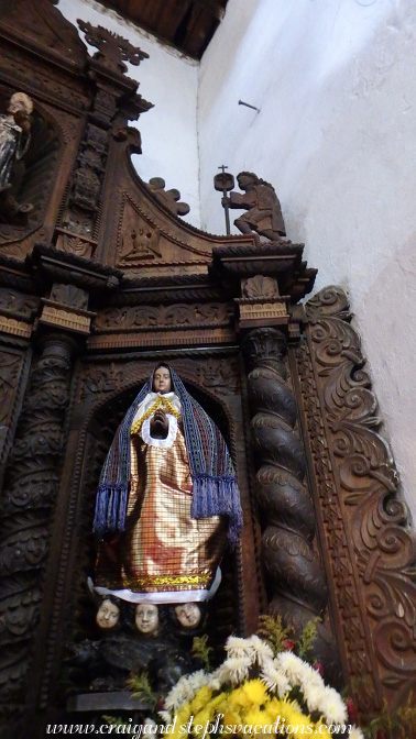 Elaborately carved wooden altar, combining Mayan and Catholic imagery