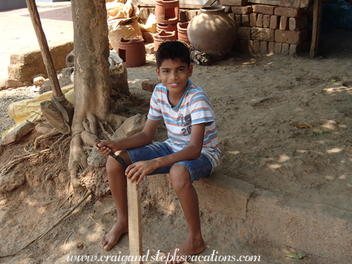Young boy prepares firewood, Cheruthuruthy Potter's Village