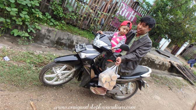 Man and son carrying thanaka on a motorbike