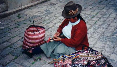 Quechua woman weaving on the sidewalk in Cusco