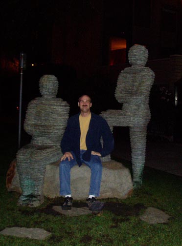 Craig sitting with the sculptures outside the Listel Vancouver