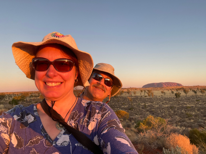 Steph and Craig riding Rocky with Uluru in the background