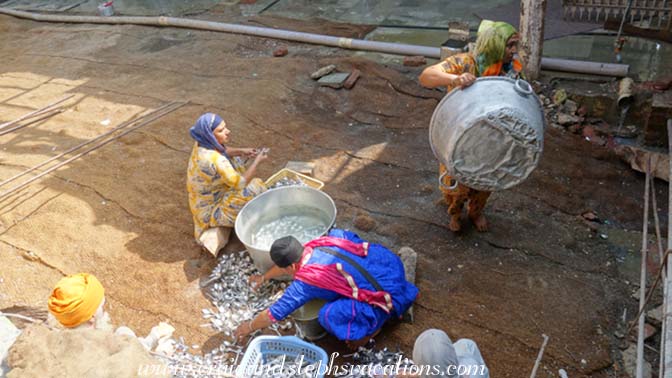 Women wash spoons at the Langar