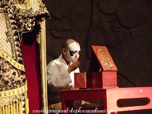 Beijing Opera actor sits on stage to apply his make up