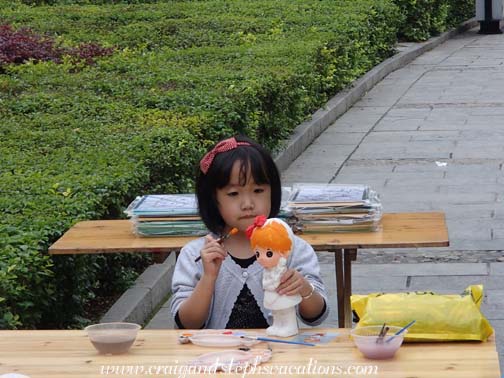 Girl painting ceramics in the park Girl painting ceramics in the park