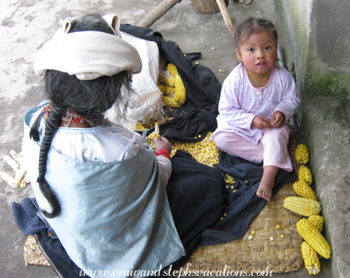 Abuelita and Sisa pick kernels off of the corn cob
