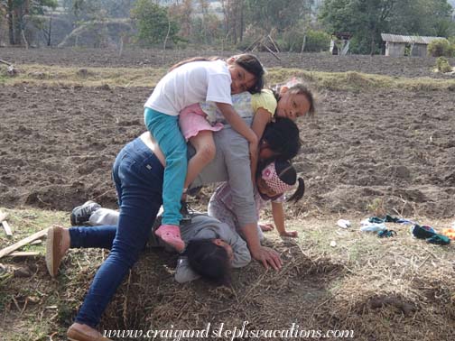 Yupanqui naps on the ground while the kids pile onto Aida Yupanqui naps on the ground while the kids pile onto Aida
