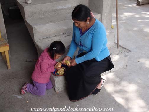 Tayanta helps Rosa with the dried corn Tayanta helps Rosa with the dried corn