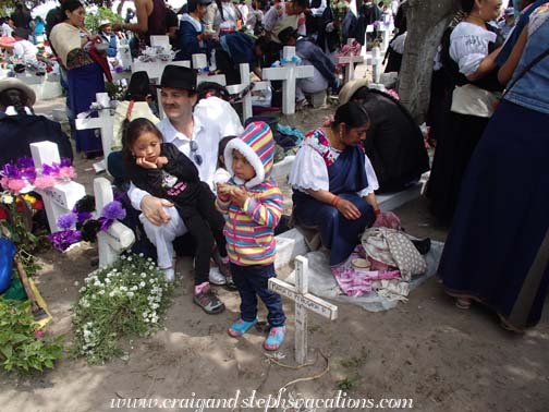 The family eats with their community at the cemetery The family eats with their community at the cemetery