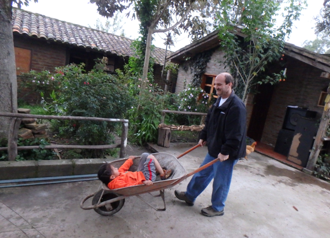 Achi Taita takes Yupanqui for a ride in the wheelbarrow