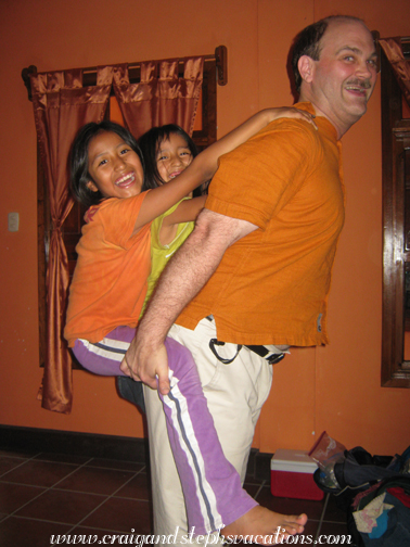 Craig gives Yoselin and Aracely a piggy-back ride