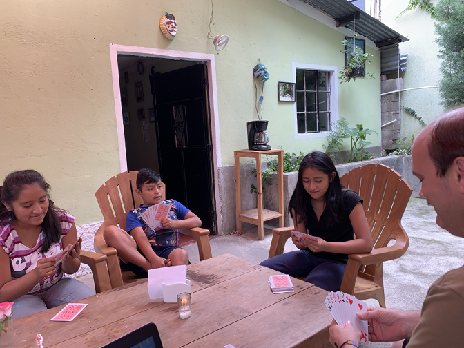 Yasmin, Eddy, Aracely, and Craig play cards