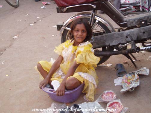 Little girl sitting in a plastic bowl, Sardar Market Girdikot, Jodhpur