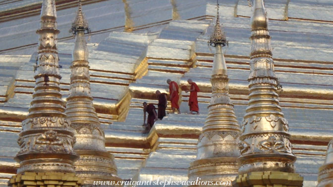 Monks walk on the octagonal ridges of Shwedagon Pagoda looking for gems displaced by birds