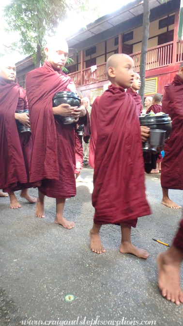 Monks queue for the last meal of the day at Mahagandayon Monastery