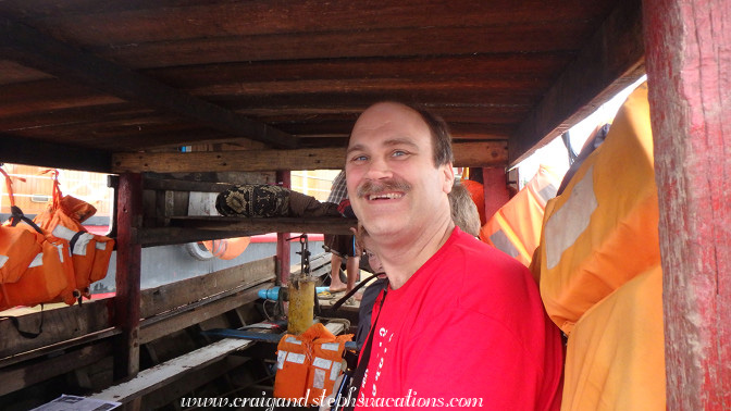 Sitting in the makeshift wheelhouse of the ferry