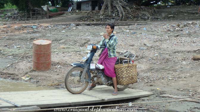 Woman on a scooter prepares to board a ferry