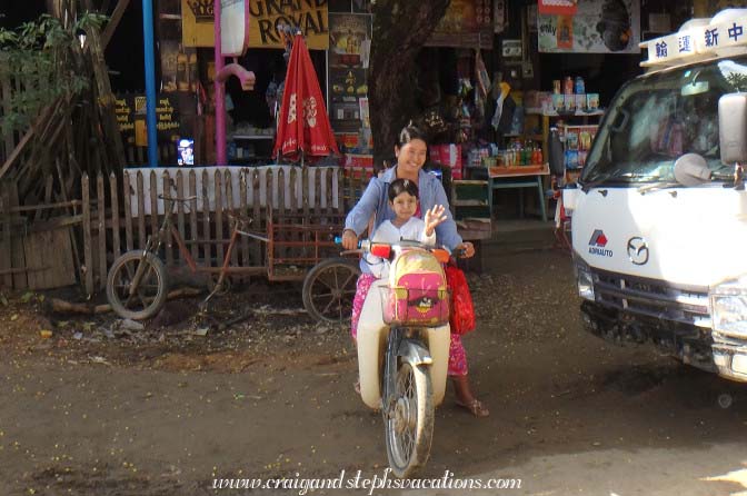 Little girl waves from a motorbike