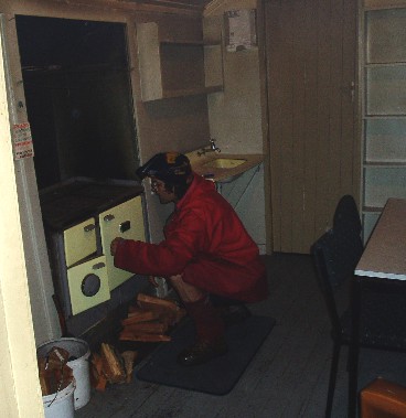 Stan lighting the stove in the cabin